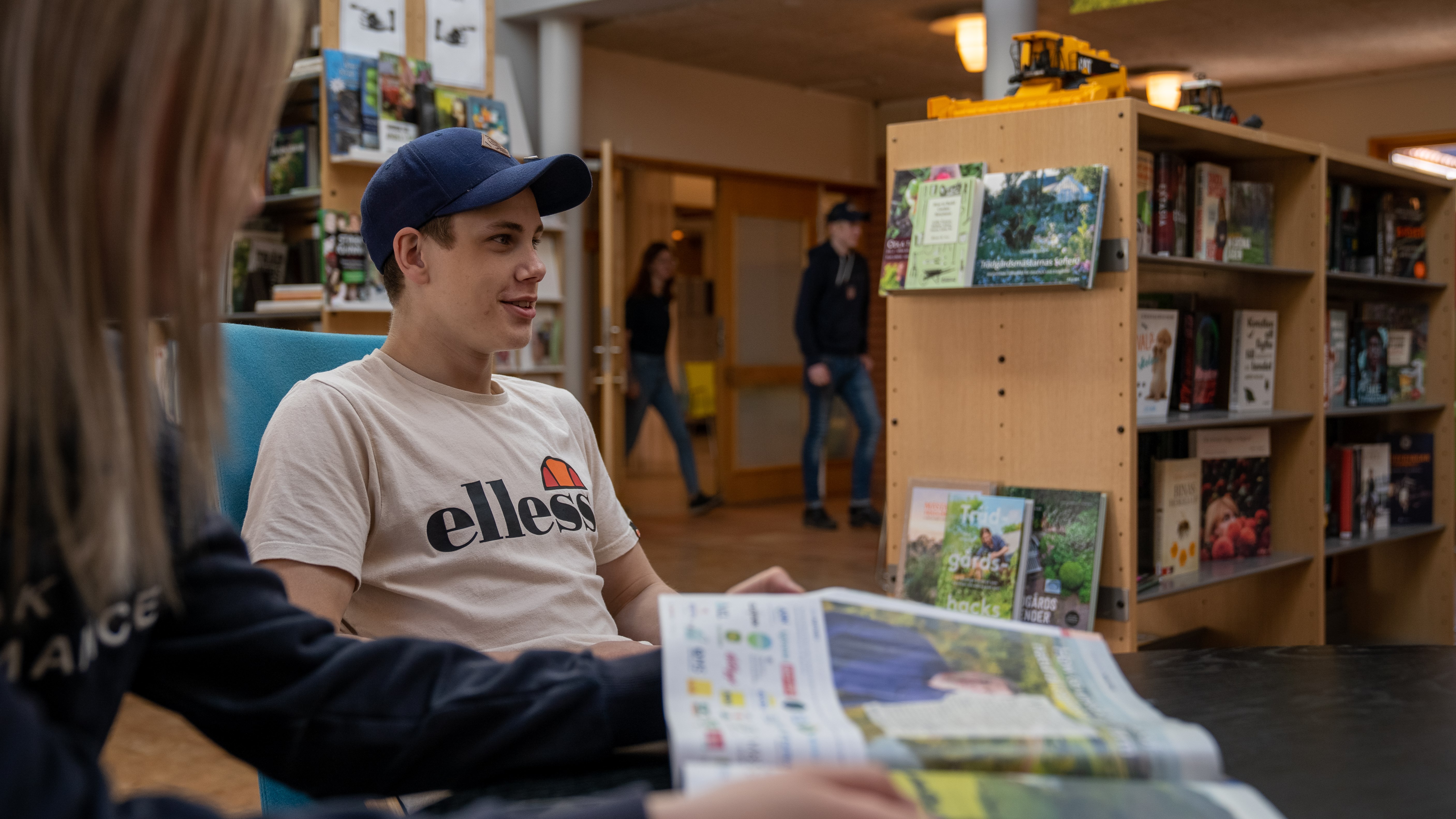 Elever sitter ner i biblioteket och tittar i tidningar