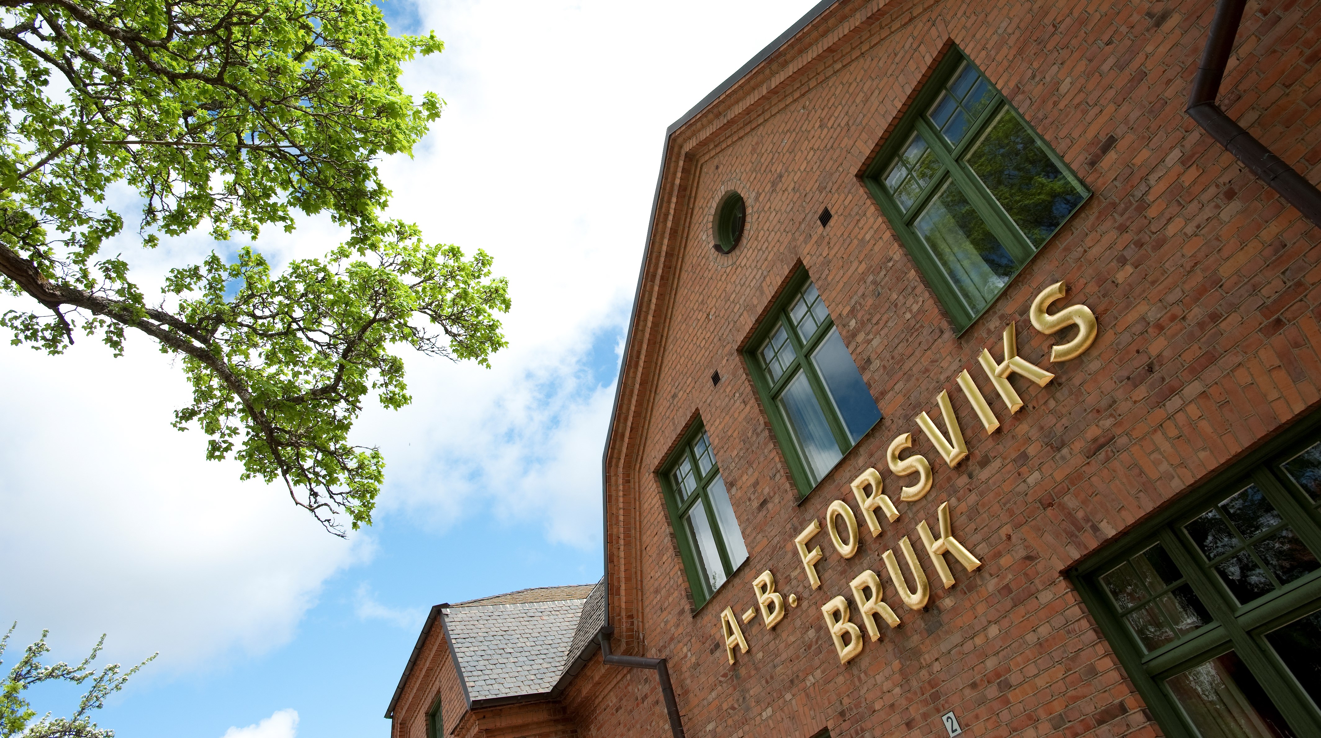 En bild på en brun tegelbyggnad med fasadtexten Forsviks bruk