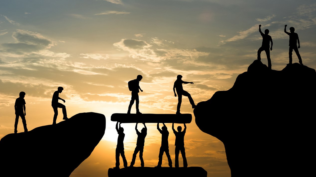 Grupp av människor bestiger berg tillsammans