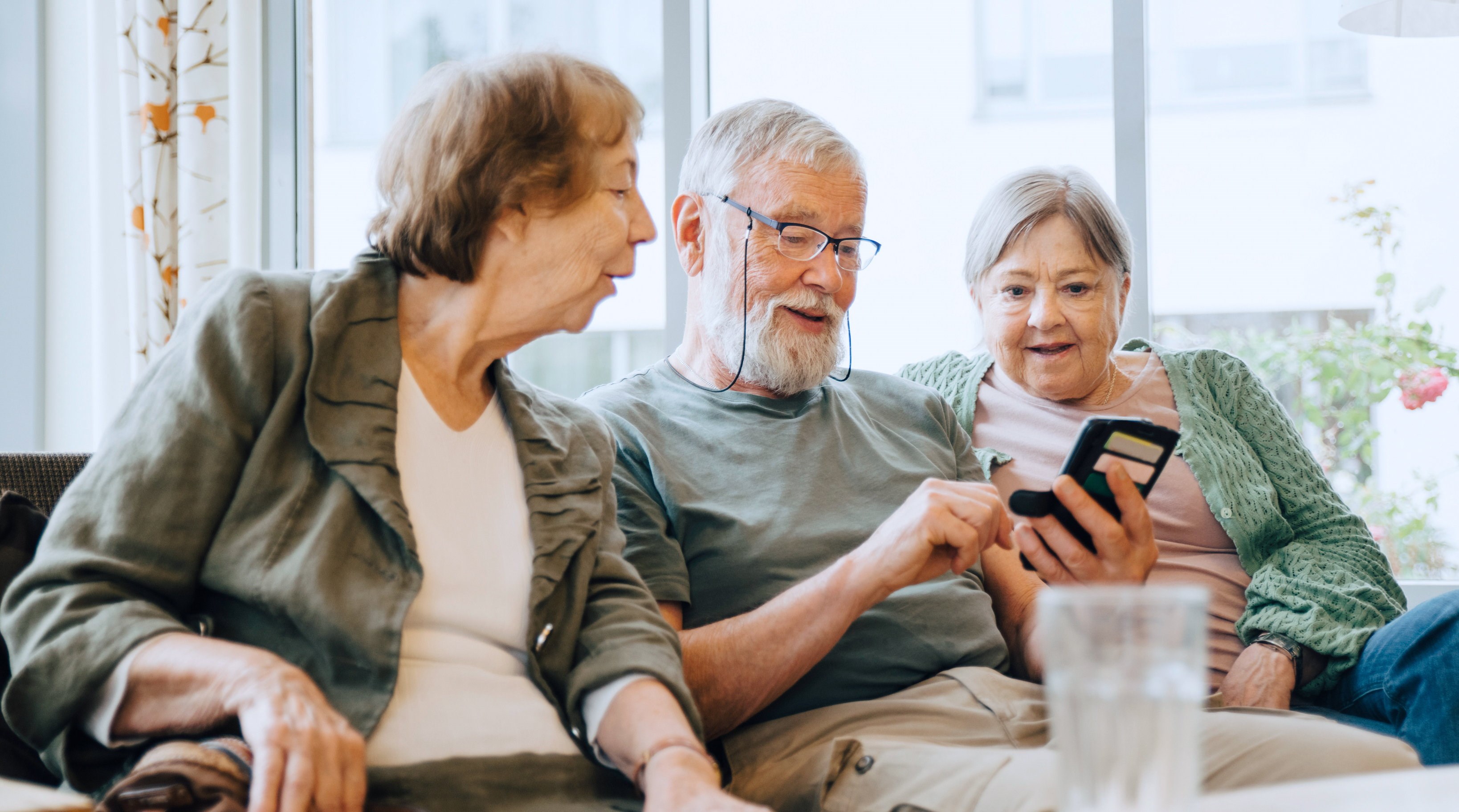 Tre personer med mobil