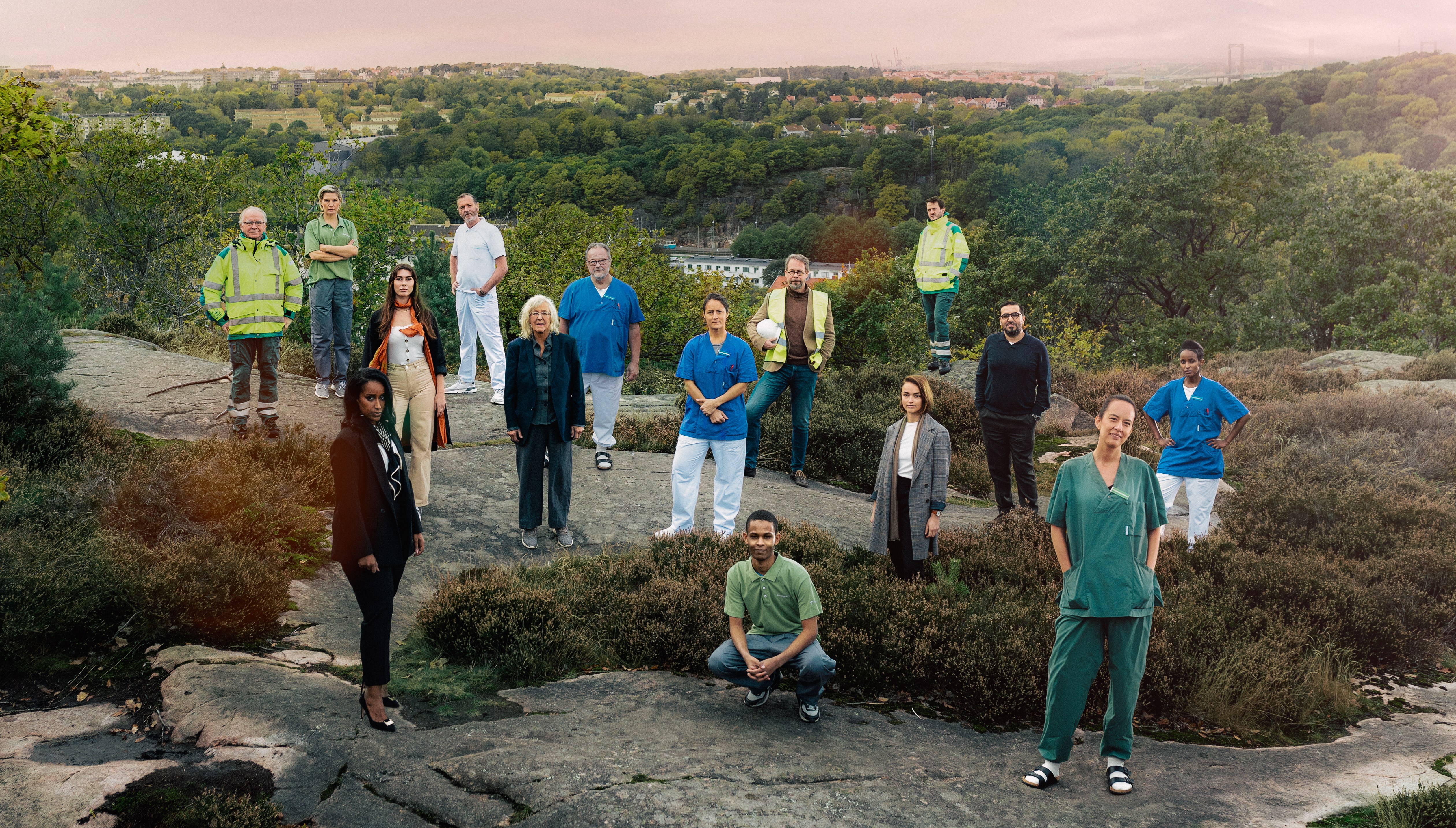 Medarbetare i olika yrken står på en klipphäll.