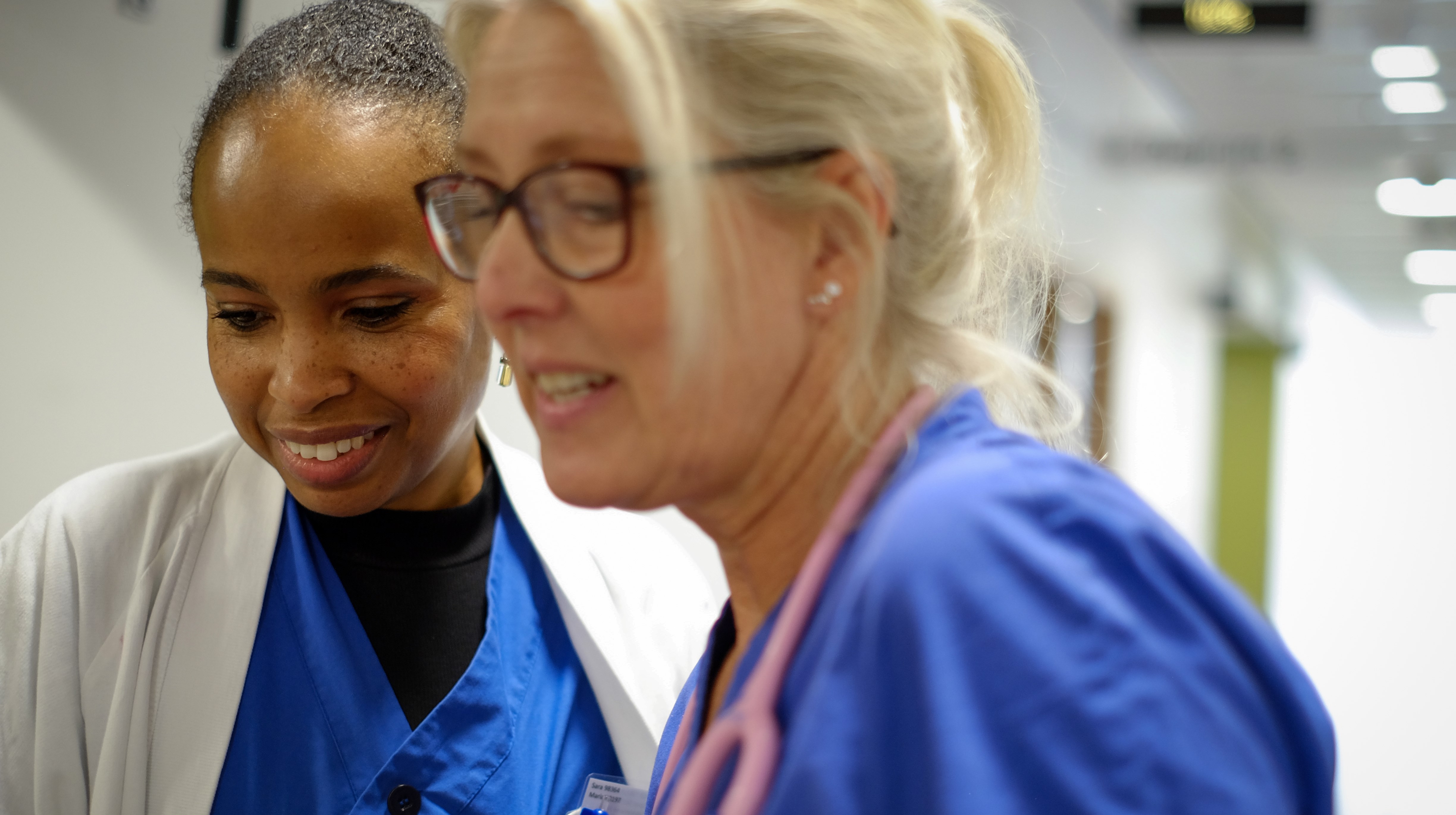 Samtal i korridor mellan medarbetare i vården.