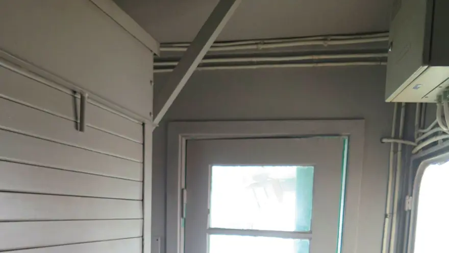 Inifrån kran 43, dörr som leder ut och brandsläckare, vita väggar